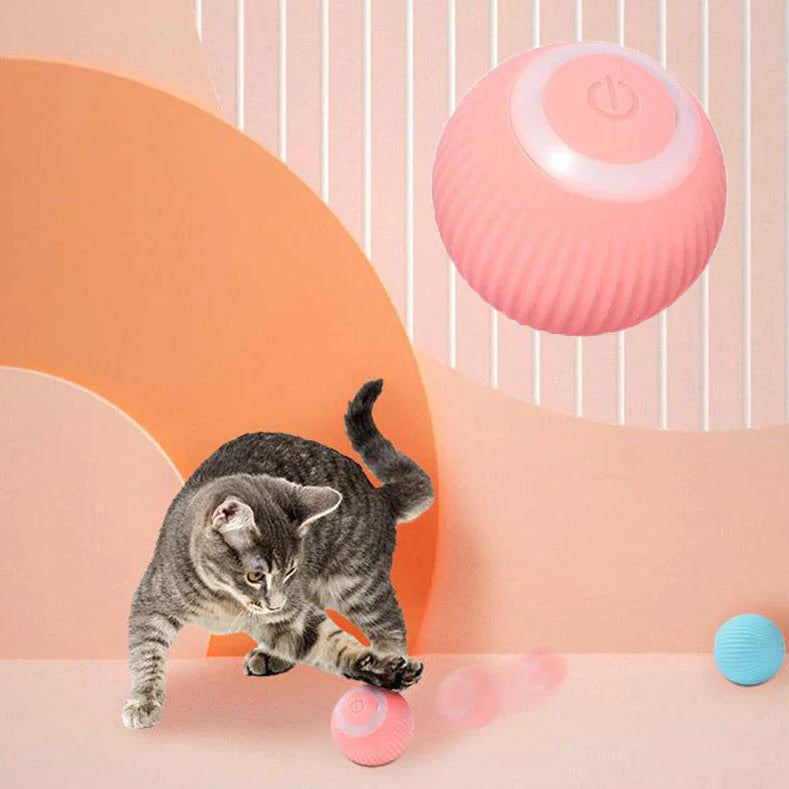 Cat playing with a pink electronic device on a colorful background
