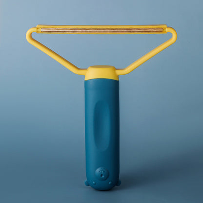 Blue and yellow pet hair remover on blue background showing wire scraper head detail — reusable lint and pet hair remover
