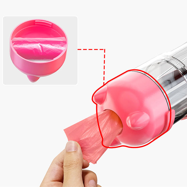 Close-up of pink dog bottle base showing built-in poo bag dispenser with bag being pulled through — portable dog walk bottle with waste bag storage
