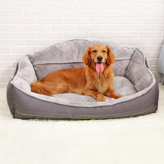 Dog lying on a gray pet bed with a white brick wall background