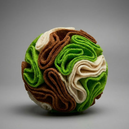 Dog snuffle ball in green, brown and cream fleece on grey background — hide and seek treat ball for dogs