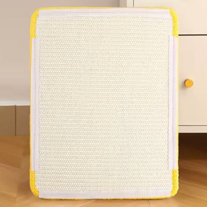 Plain natural sisal wall-mounted cat scratcher with yellow border leaning against white cabinet showing velcro wall adhesive pads — cat scratching pad