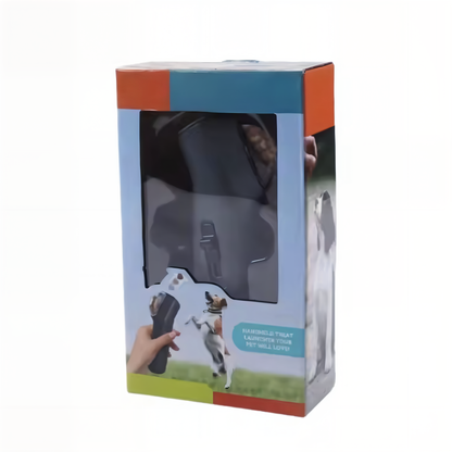 Pet treat launcher in retail packaging box showing product through window — handheld treat launcher for dog training