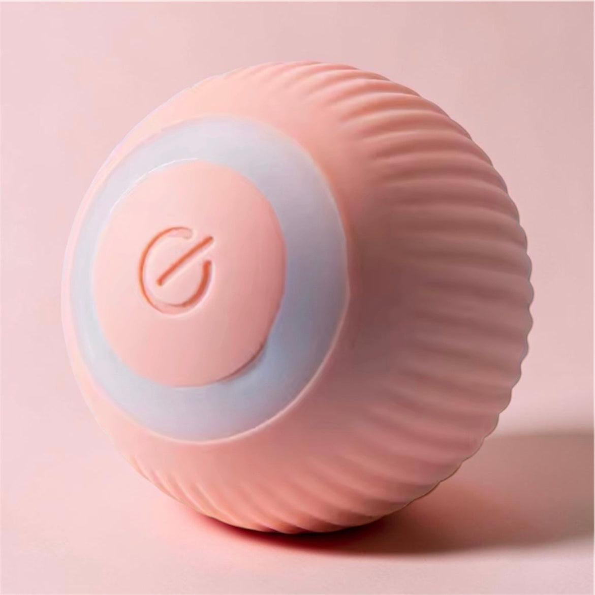Pink ribbed automatic rolling ball toy on matching pink background showing textured surface detail — self-moving pet toy